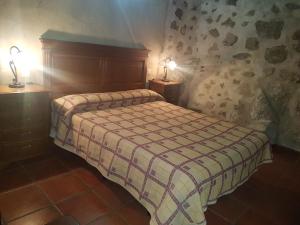 1 dormitorio con 1 cama y 2 lámparas en 2 mesas en Casa Rural El Molino II en San Bartolomé de Pinares