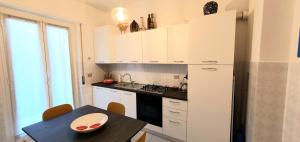 a kitchen with white cabinets and a table with a bowl on it at COMODO AL MARE in Lerici
