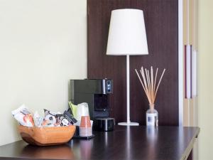 a table with a coffee maker and a lamp on it at Residenza Viani Guest House in La Spezia