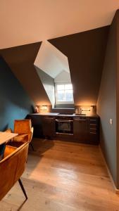 an attic room with a table and a window at H-85 SUITES LEVEL 5/10 in Koblenz