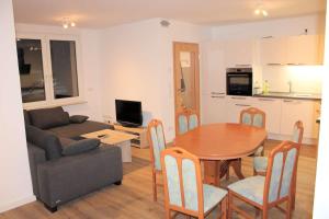a kitchen and a living room with a table and a couch at Work & Stay in Jena in Neuengönna