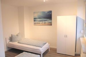 a small room with a bed and a white cabinet at Work & Stay in Jena in Neuengönna