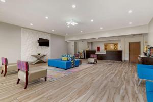 Comfort Inn & Suites Selma near Randolph AFB في Selma: غرفة معيشة كبيرة مع أريكة وكراسي زرقاء