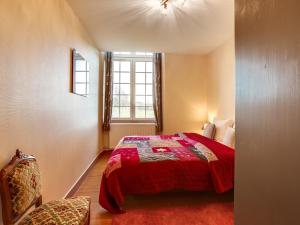 ein Schlafzimmer mit einem roten Bett und einem Fenster in der Unterkunft Le Seigneur de Bons in Bons-Tassily