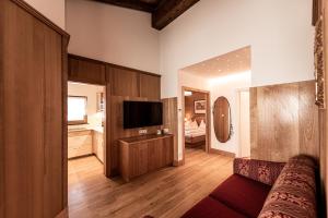 a living room with a couch and a television at Aparthotel Kastel Seiser Alm in Castelrotto