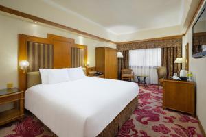 een groot wit bed in een hotelkamer bij Hotel Sintra in Macau