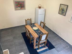 a dining room table with chairs and a refrigerator at Relax and Explore, Alva Apartment in Solin