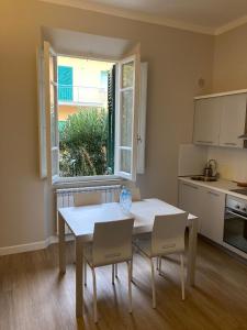 eine Küche mit einem Tisch und Stühlen sowie einem Fenster in der Unterkunft Nonno 'Drea guest house in Castiglione della Pescaia