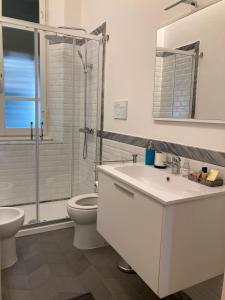 La salle de bains est pourvue de toilettes, d'un lavabo et d'une douche. dans l'établissement Nonno 'Drea guest house, à Castiglione della Pescaia