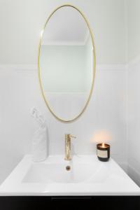 a bathroom sink with a mirror and a candle at Elite Apartments Old Town Deluxe in Gdańsk