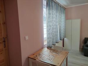 einen Tisch und Stühle in einem Zimmer mit Fenster in der Unterkunft Apartamenty Daola in Danzig
