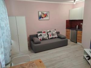 a living room with a couch and a kitchen at Apartamenty Daola in Gdańsk