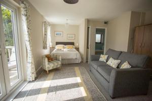 una sala de estar con un sofá y una cama en Pant-Y-Celyn Studio Apartment, en Aberaeron