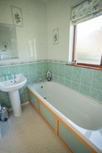 a bathroom with a bath tub and a sink at Pant-Y-Celyn Studio Apartment in Aberaeron