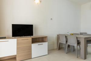 een woonkamer met een tafel en een televisie bij Residenza Cormorani 2 in Golfo Aranci