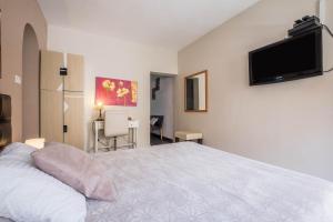 a bedroom with a bed and a flat screen tv on the wall at Estudio con Balcón Estrella de Mar in Los Abrigos