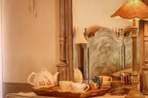 une table avec des tasses, une lampe et un lit dans l'établissement Mas en Baronnies Provençales, à Eygaliers