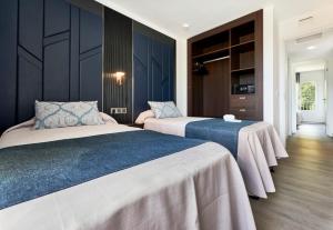 two beds in a room with blue walls at O7 Be Klub in Port d'Alcudia +98 photos