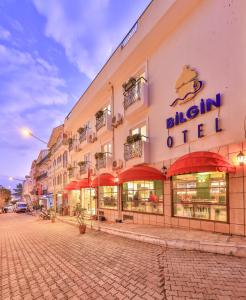 a building with red umbrellas on a street at Kas Bilgin Hotel in Kas