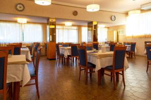 フォッローニカにあるHotel Parco dei Piniのレストラン内のダイニングルーム(テーブル、椅子付)
