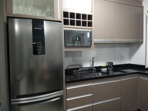 a kitchen with a stainless steel refrigerator and a sink at Beach House Nascer do Sol in Florianópolis