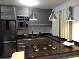 uma cozinha com uma placa de fogão e um frigorífico em Beach House Nascer do Sol em Florianópolis