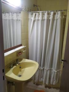 a bathroom with a sink and a shower curtain at Amplio y Luminoso en zona Guemes in Mar del Plata +7 photos