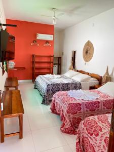 a hotel room with three beds and a tv at Pousada Meu Sossego in Barra Grande +164 photos