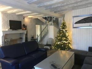 a living room with a christmas tree and a couch at Gîte LE LOGIS De La CHARNIE Confort pour 14 personnes à Chemiré-En-Charnie in Chemiré-en-Charnie