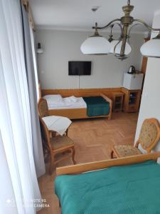 ザコパネにあるPokoje Gościnne Zakopaneのベッド1台、椅子2脚、テレビが備わる客室です。