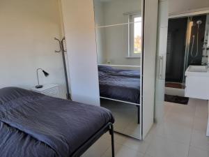 a small bedroom with a bed and a mirror at Guest House Scheldevallei in Merelbeke