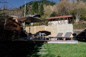 a patio with a table and chairs and an umbrella at Mountain Mama Ferienhaus in Schliersee