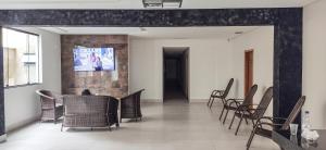 a dining room with chairs and a tv on a wall at Hotel Turismo in Trindade