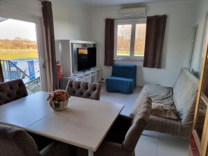 a living room with a table and chairs and a tv at Guest House Scheldevallei in Merelbeke