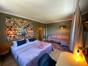 ein Schlafzimmer mit 2 Betten und einem Wandgemälde in der Unterkunft Harz Hotel & Spa Seela in Bad Harzburg