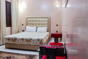 a bedroom with a bed and a red stool at Riad Aymane in Marrakech