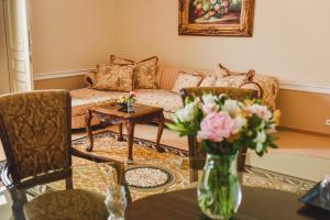 a living room with a couch and a table with flowers at Zámek Kamenný Dvůr in Kynšperk nad Ohří