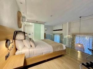 a bedroom with a bed with a lamp and a window at Hotel Emblemático Hi Suites in Santa Cruz de Tenerife