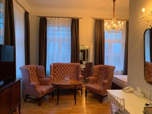 a living room with chairs and a table and a tv at Hotel Usadba in Kaliningrad