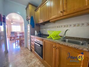 kuchnia z drewnianymi szafkami i zlewem w obiekcie La Ciñuelica, R2 Ground Floor Apartment Com pool L188 w mieście Orihuela