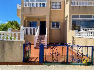 dom z niebieską bramą przed nim w obiekcie La Ciñuelica, R2 Ground Floor Apartment Com pool L188 w mieście Orihuela