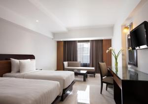 Postel nebo postele na pokoji v ubytování Hotel Santika Premiere Semarang
