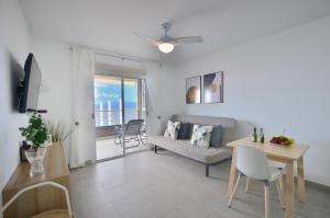 a living room with a couch and a table and a dining room at Costa Isora in Puerto de Santiago