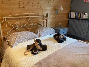 two dolls sitting on a bed in a bedroom at Gite De Saba in La Celle-Condé