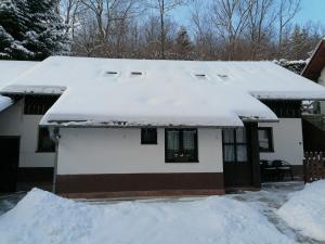 a house with snow on the roof at Privát Zvonček in Terchová