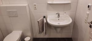 ein weißes Badezimmer mit Waschbecken und Toilette in der Unterkunft Ferienhaus Bella Vista in Gelting
