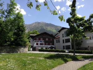uma casa com uma montanha ao fundo em Adventure Hostel em Klosters