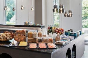 a breakfast buffet with bread and food on a counter at Stellaris Apartment Hotel in Garching bei München