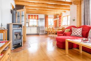 ein Wohnzimmer mit einem roten Sofa und einem Kamin in der Unterkunft Sonnenchalet 1 im Salzburger Lungau in Mariapfarr
