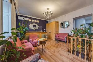 a living room with pink furniture and a chandelier at House 52 Boutique Hotel in Tbilisi City